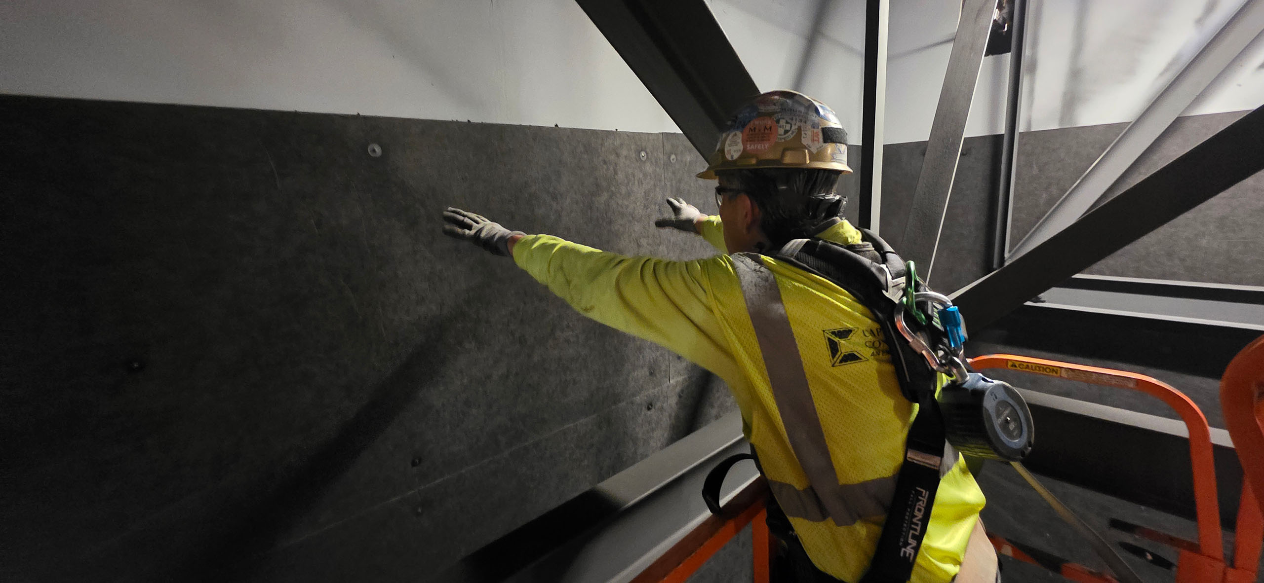 An installers places acoustic panels on a wall in an entertainment complex