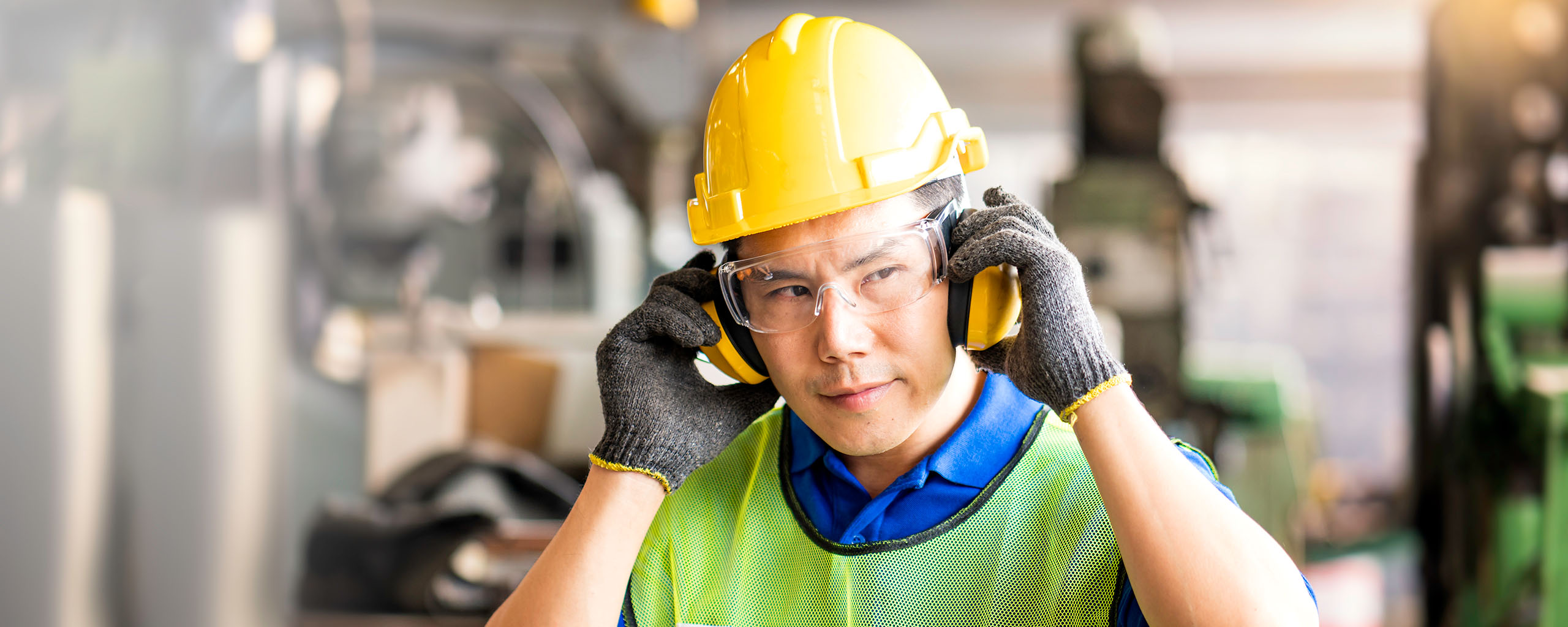 A construction worker wears hearing protection in an industrial setting