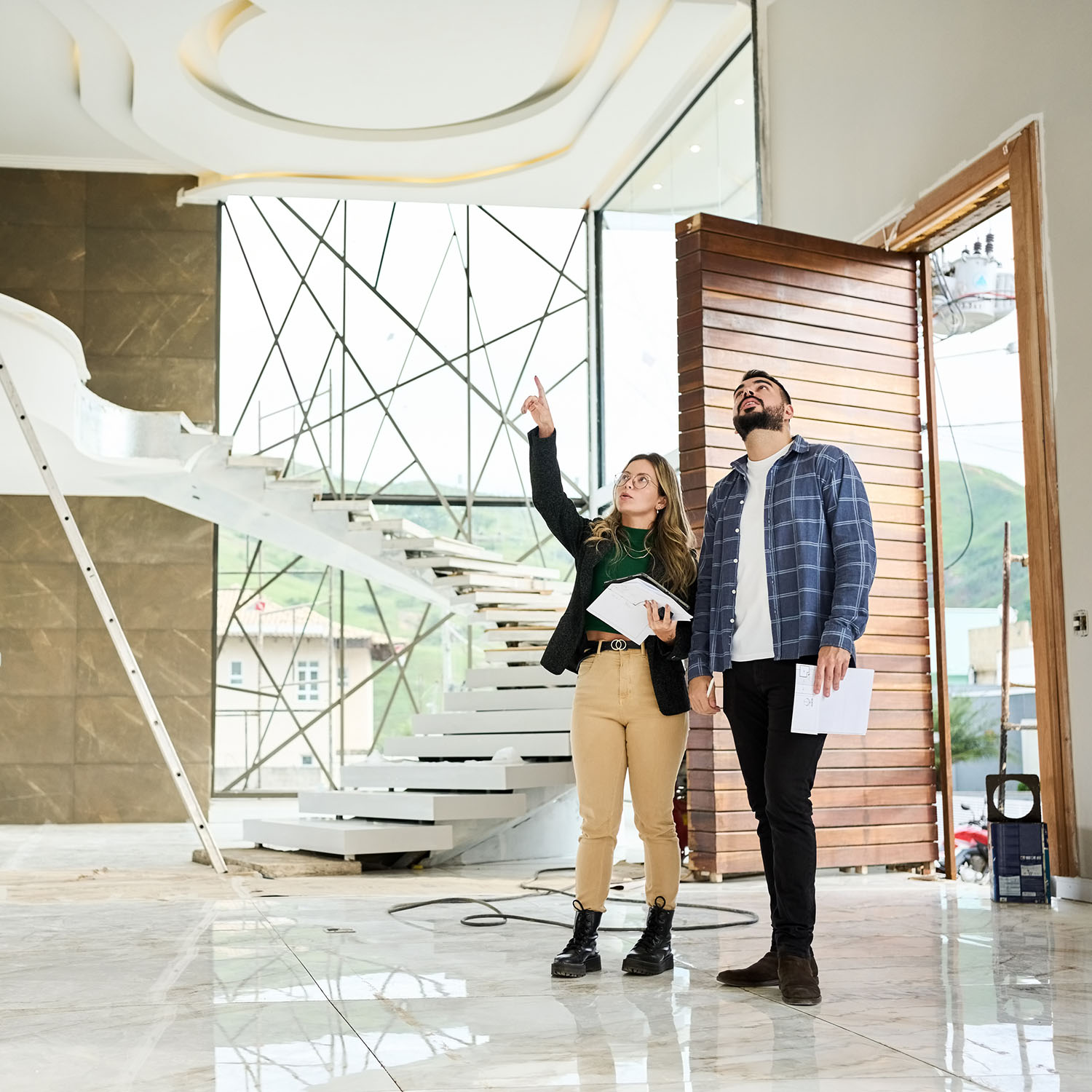 Two people in a foyer at a construction site discussing acoustic treatment